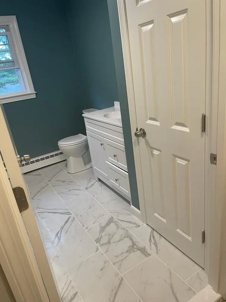 Marble look floor tile with a white vanity in a finished bathroom