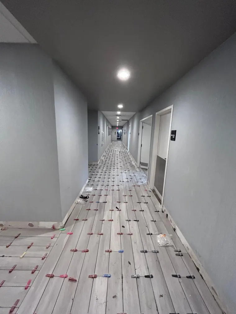 Wood look plank flooring being installed down a hallway