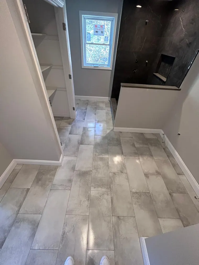 Wood look tile plank floor running through a finished room