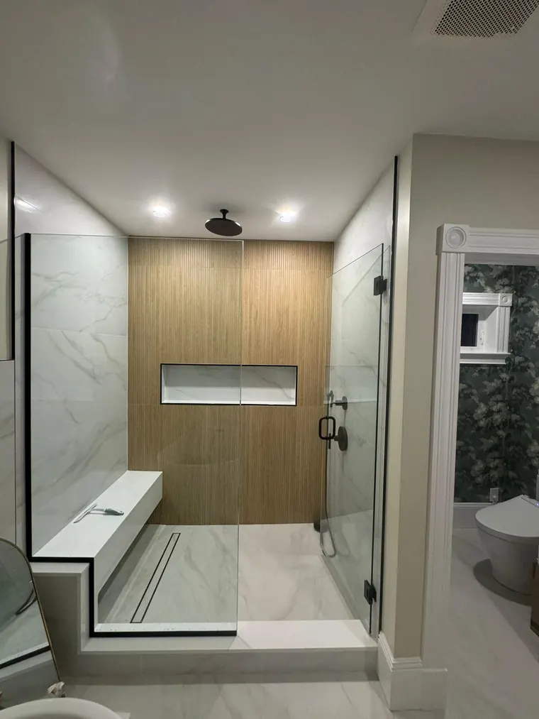 Curbless walk in shower with a wood look feature wall and a built in bench