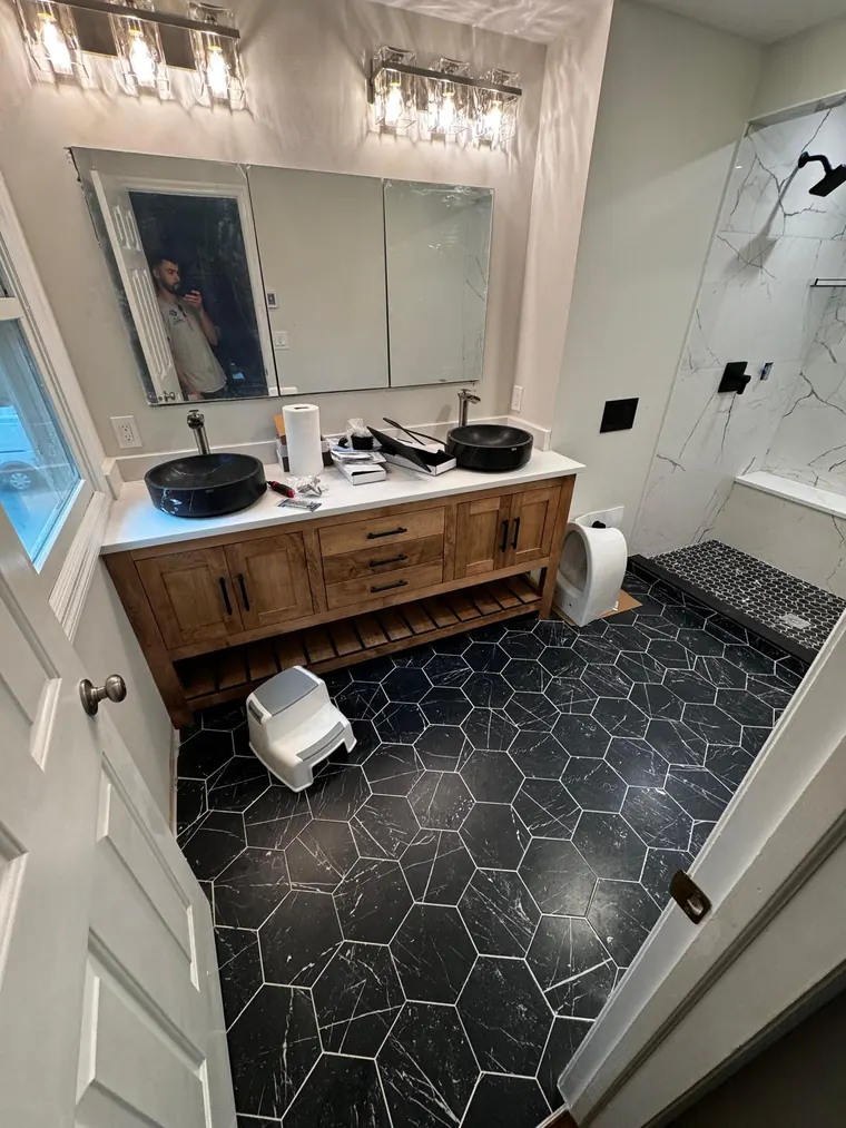 Double vanity over a black hexagon tile floor in a finished bathroom