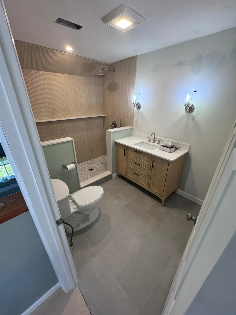 Wood look tile wall behind a vanity in a compact bathroom