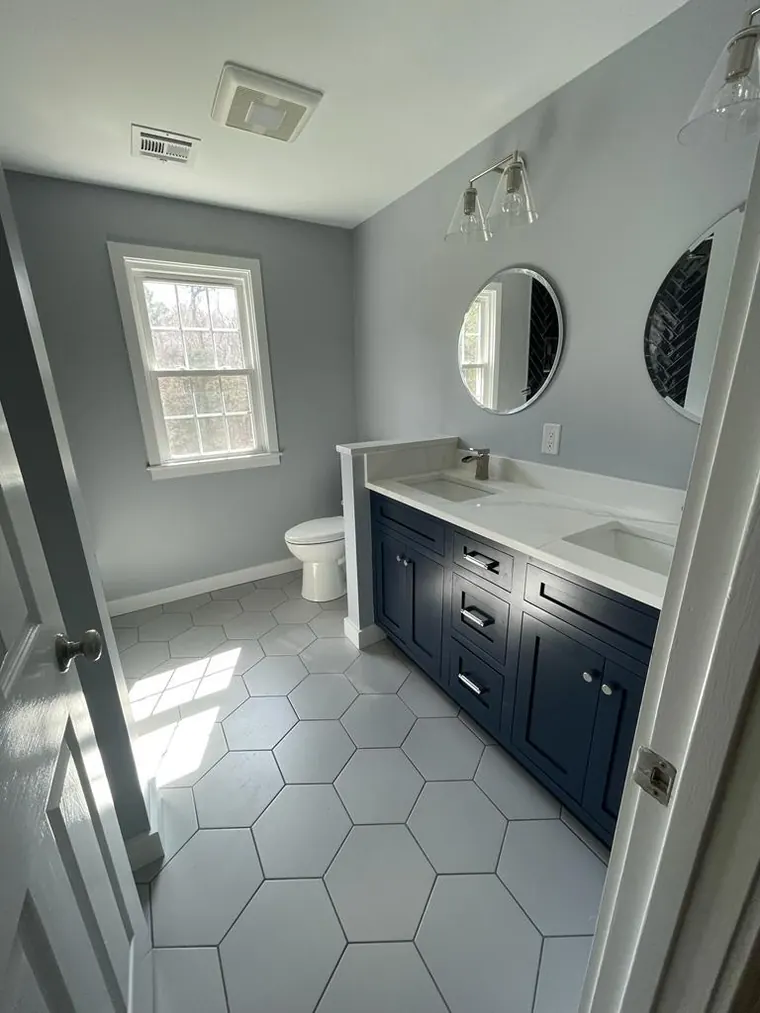 Hexagon floor tile with a navy vanity in a finished bathroom