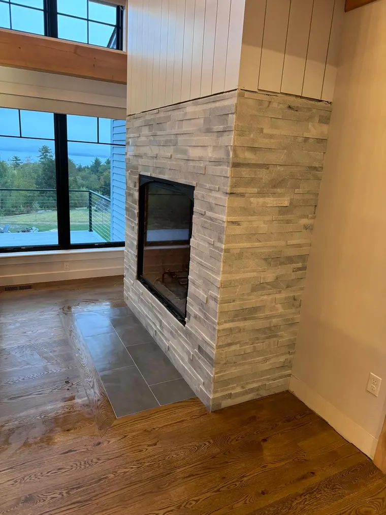 Stacked stone fireplace surround built into a living room wall